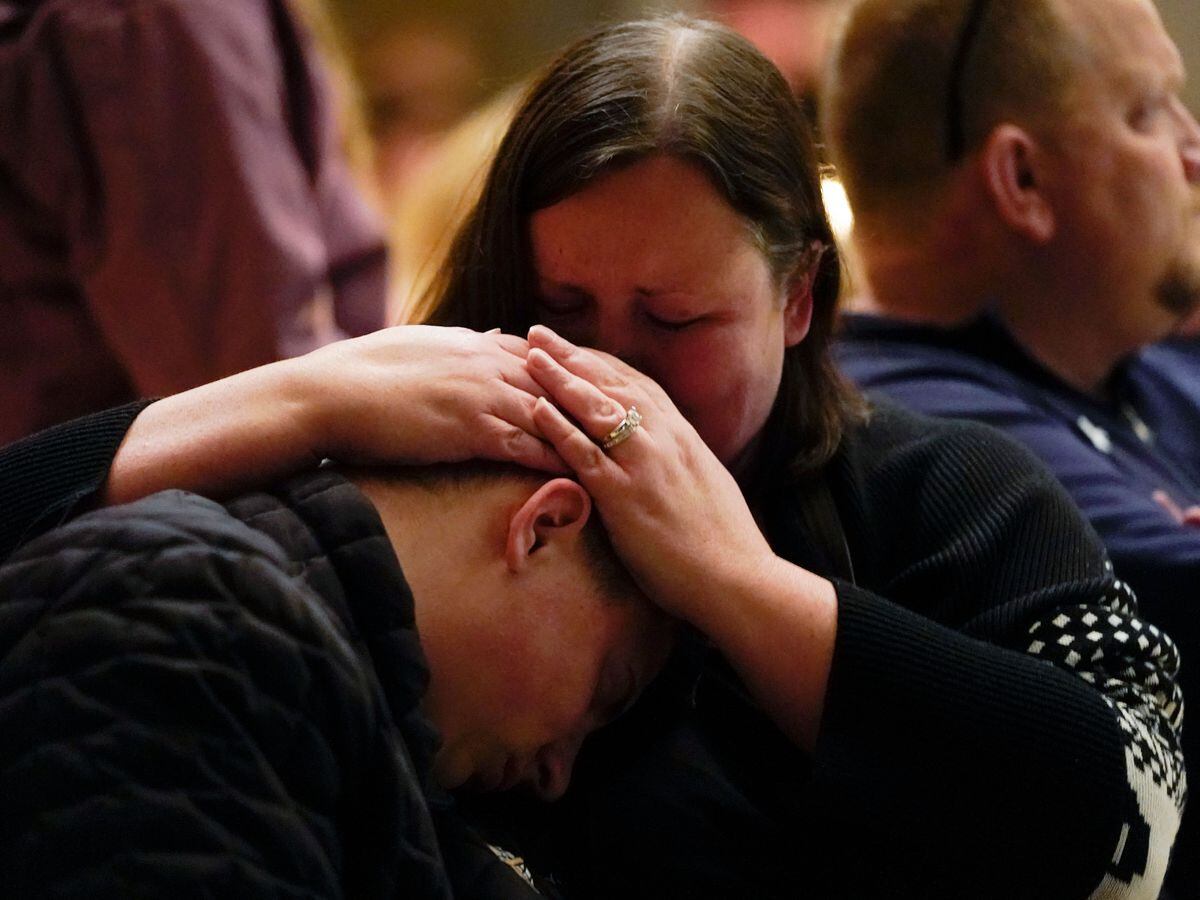 Aiden Watson, who was injured at Oxford High School, attends a vigil with his mother at LakePoint Community Church in Oxford, Michigan