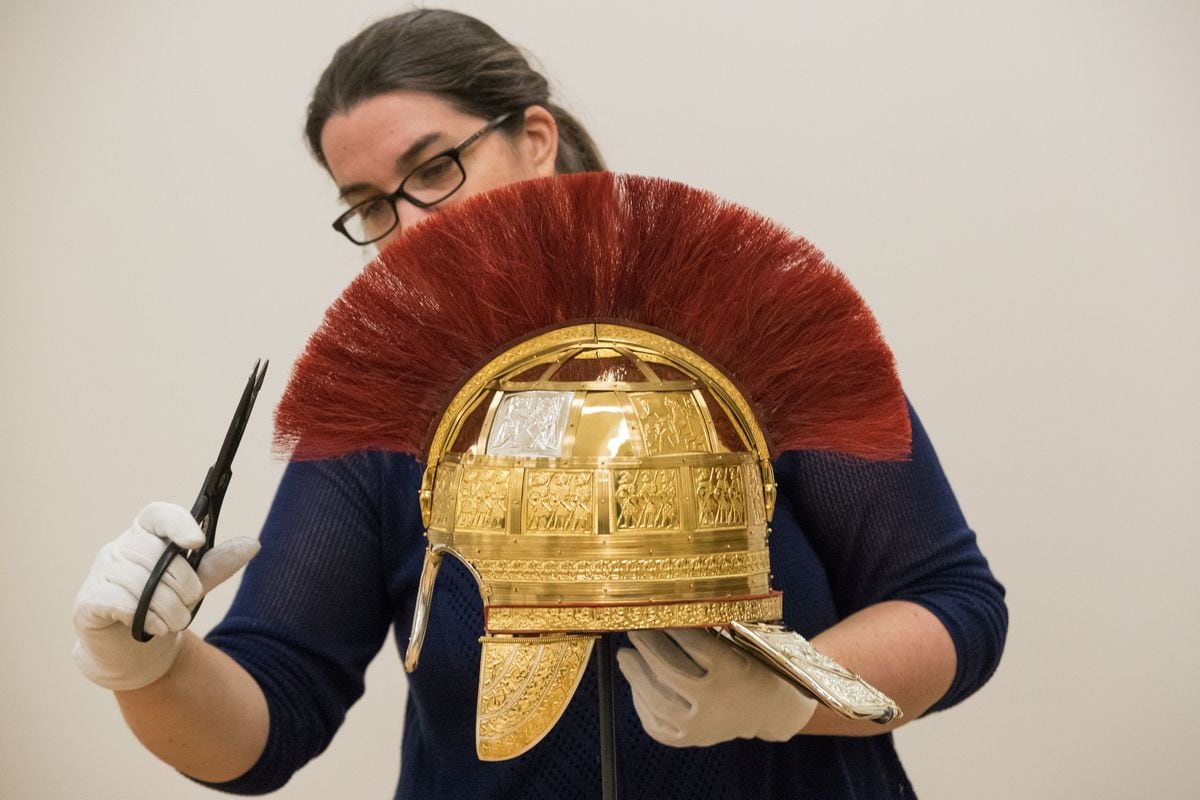 Conservator Pieta Greaves trims the crest of a reconstruction of a helmet