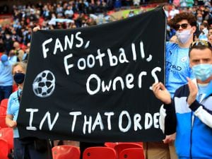 Fans hold up a banner protesting against the European Super League
