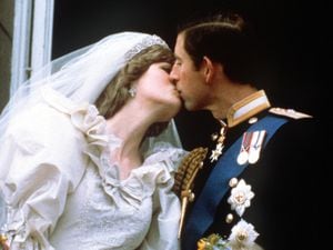 The newly married Prince and Princess of Wales (formerly Lady Diana Spencer) kissing on the balcony of Buckingham Palace after their wedding ceremony at St. Paul's cathedral