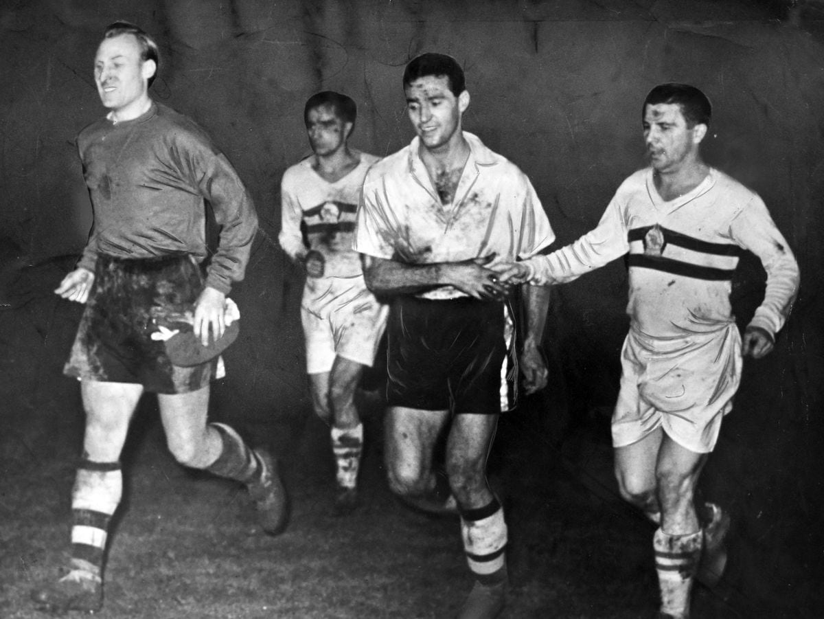 Wolves v Honved at Molineux, on December 13, 1954, in which the home team wore their luminous shirts. The original caption read: "Hungarian and Honved skipper Ferenc Puskas showed his sportsmanship through a handshake for Wolves full back Eddie Stuart as the teams trooped off the field, Wolves dazed with success, Honved dazed in defeat. Bert Williams (left) grinned happily under his coating of Molineux mud."