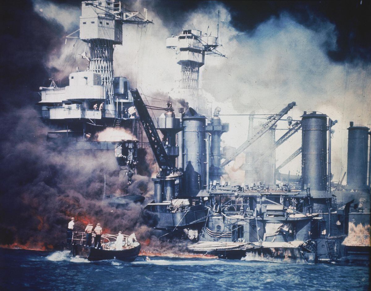 A small boat rescues a USS West Virginia crew member from the water.