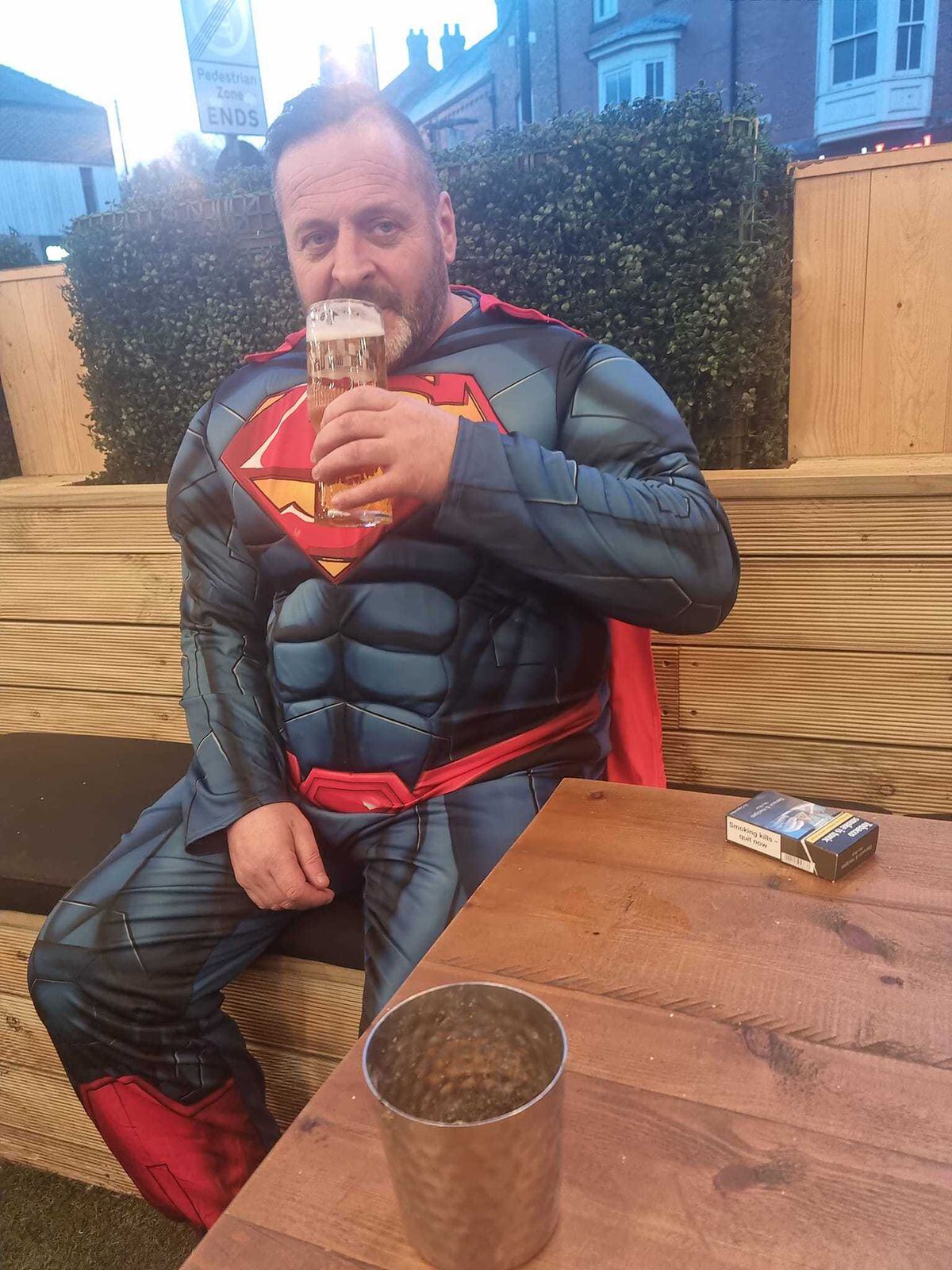 Superman having a well earned pint