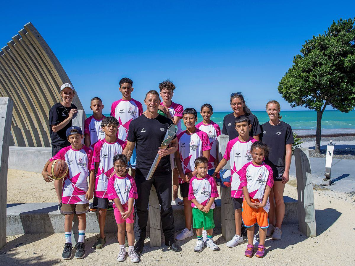 From left: Hockey athlete Emily Gaddum, Chef de Mission Nigel Avery, Netball’s Irene van Dyk and swimmer Emma Godwin pose for a photograph with young local basketball players during the Queen’s Baton Relay in Napier, New Zealand