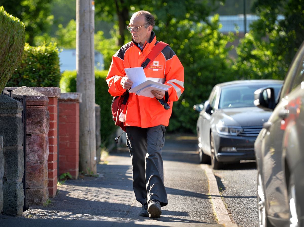 Postman Lee Sammons on his rounds in Heath Town 