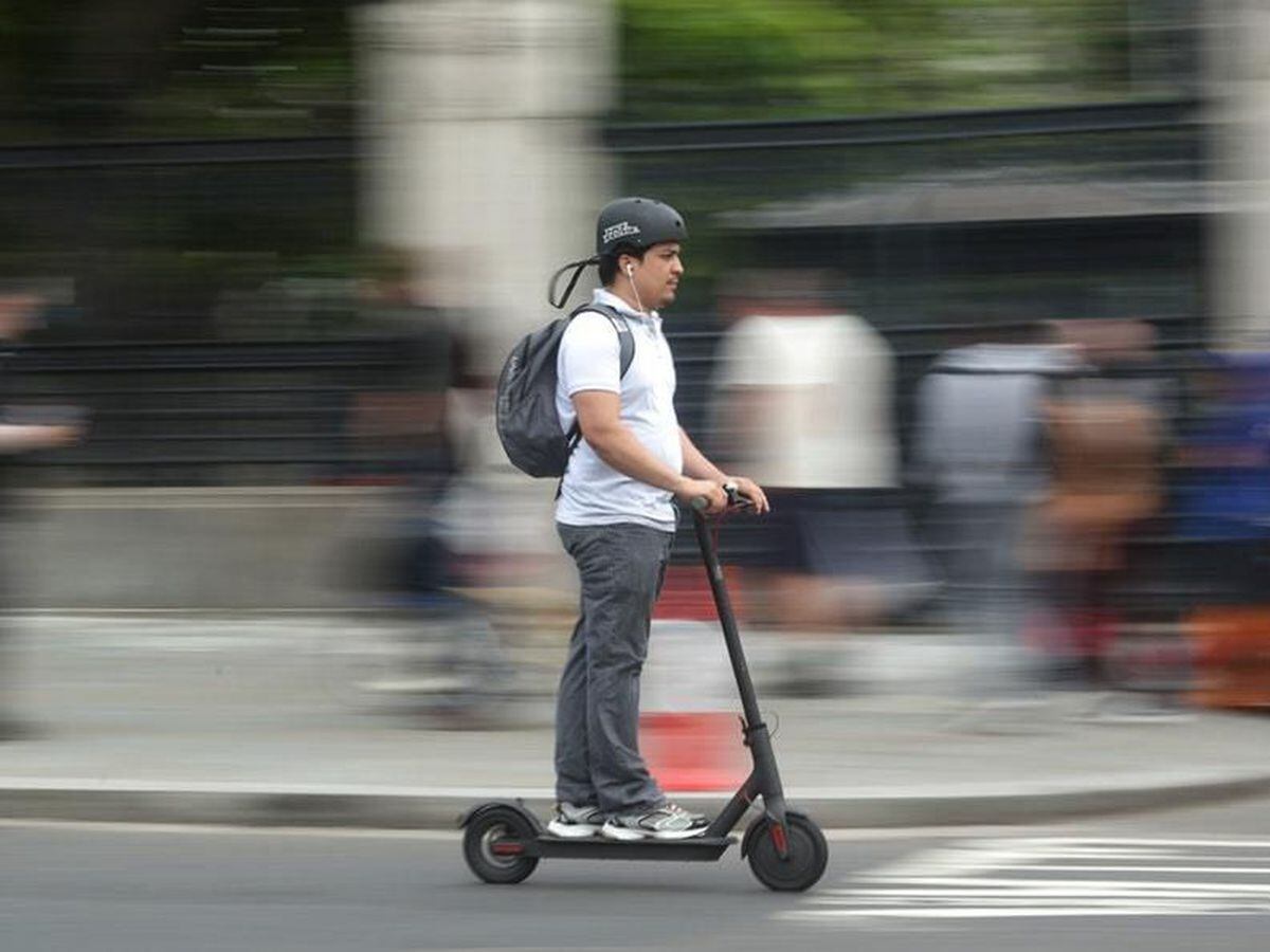 A stock image of a man on an electric scooter