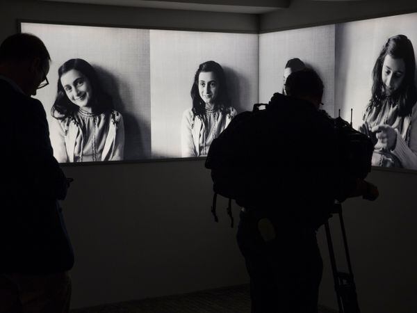 A journalist takes images of pictures of Anne Frank at the renovated Anne Frank House Museum in Amsterdam, Netherlands