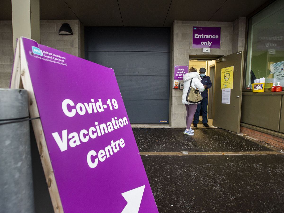 A member of the Belfast Health and Social Care Trust greets a person as they arrive at the Covid-19 vaccination centre at Belfast's Royal Victoria Hospital