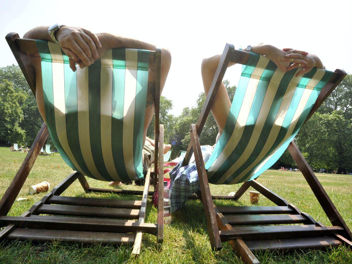 People soak up the sun on the deckchairs in central London’s St James’s Park