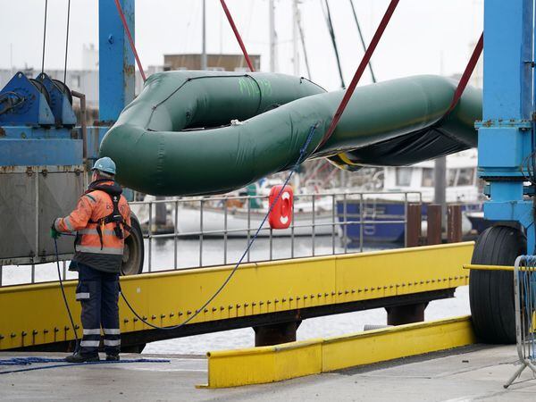 Small boats used to cross the Channel by people thought to be migrants are removed from the water and documented at the Port of Dover in Kent before being taken away for storage