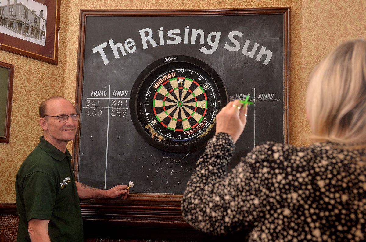 Malcolm and Julie Roberts playing darts. 