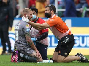 Catalans Dragons' Sam Tomkins is treated on the pitch for a head injury
