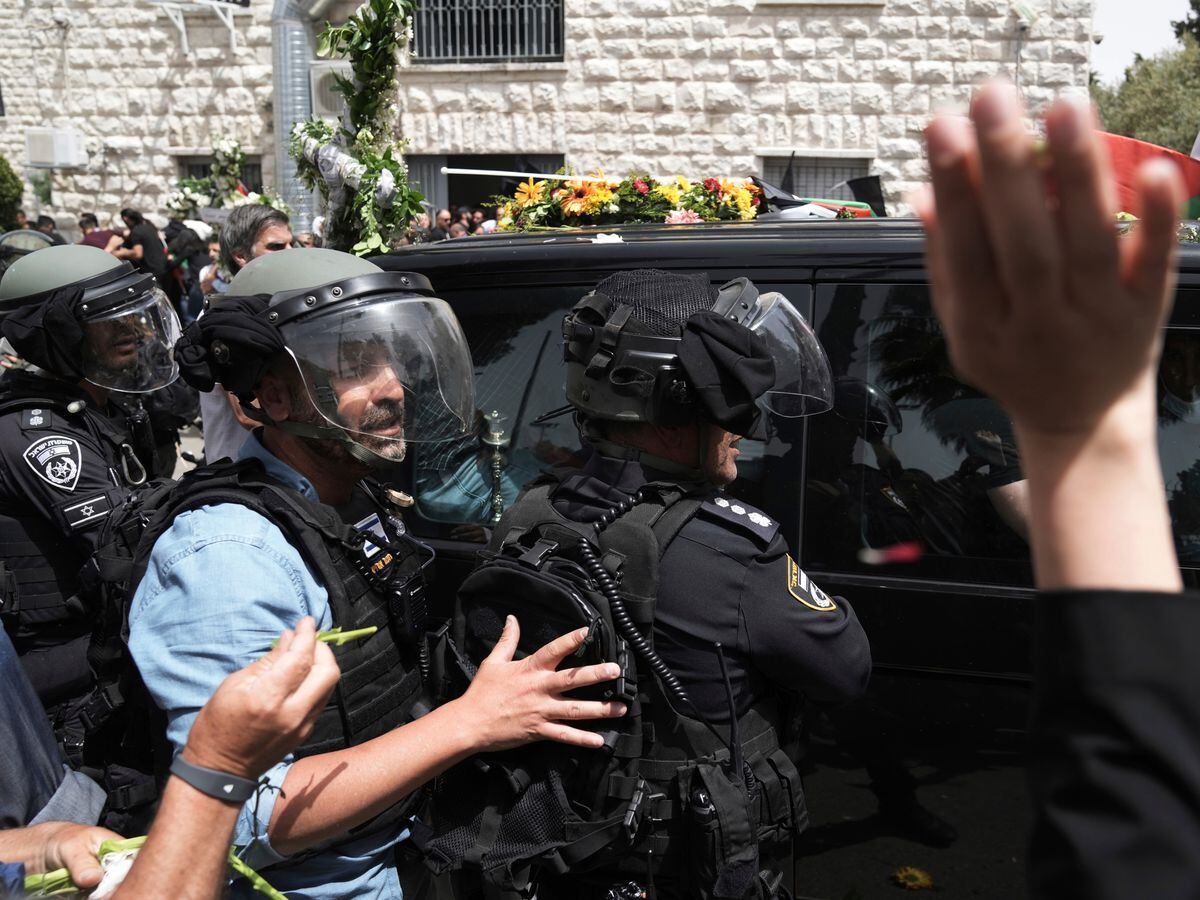 Israeli police in riot gear surround the vehicle carrying the coffin of slain Al Jazeera veteran journalist Shireen Abu Akleh to her final resting place in east Jerusalem on Friday May 13 2022