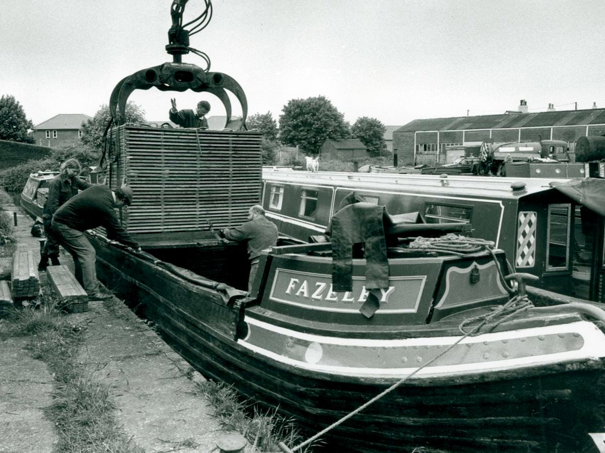 Workmen load freight onto a canal boat 