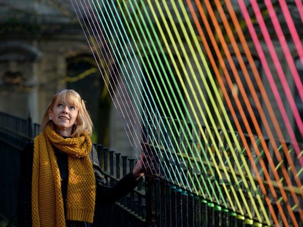Artist Kathleen Fabre with her rainbow art installation before it was wrecked by vandals
