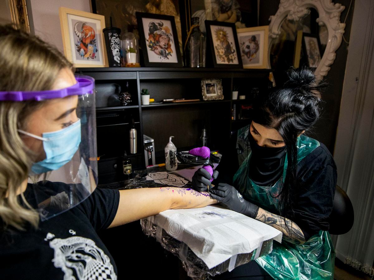 Tattoo artist Kirsty Mick (right) tattooing customer Chloe McEnhill at Belfast City Skinworks