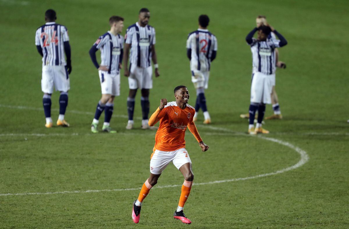 Blackpool's Marvin Ekpiteta celebrates as West Bromwich Albion players stand dejected following the Emirates FA Cup third round match at Bloomfield Road.