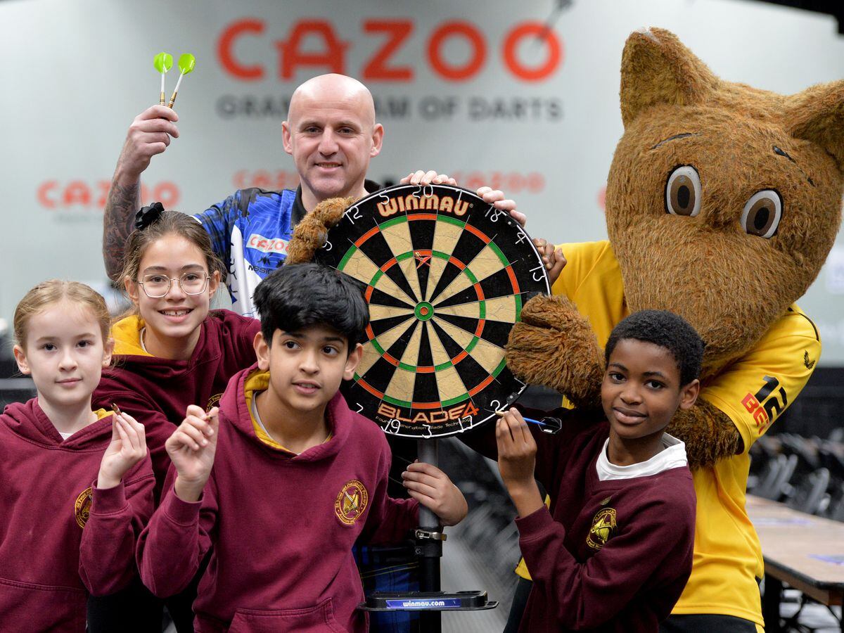 Students from SS Peter and Paul Catholic Academy pose with Wolfie and Alan Soutar at the Grand Slam of Darts arena in Aldersley Leisure Village