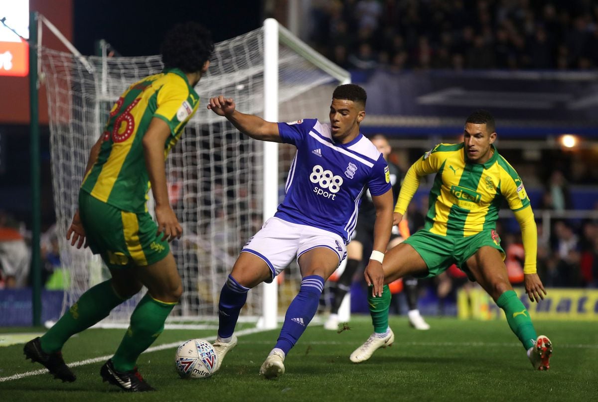 Birmingham City's Che Adams (centre) is tackled by  West Bromwich Albion's Ahmed Hegazi (left) and Jake Livermore. 