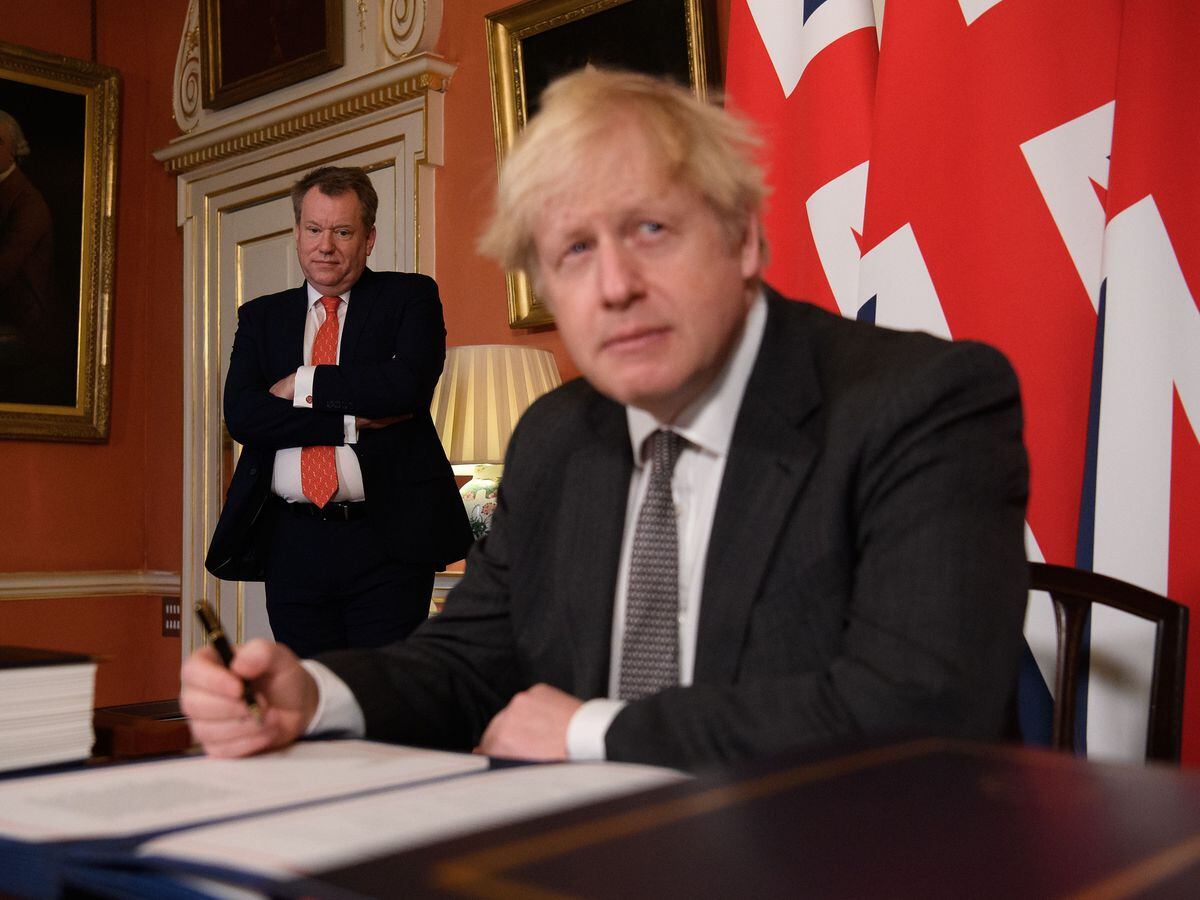 UK chief trade negotiator, David Frost looks on as Prime Minister Boris Johnson signs the EU-UK Trade and Co-operation Agreement at 10 Downing Street