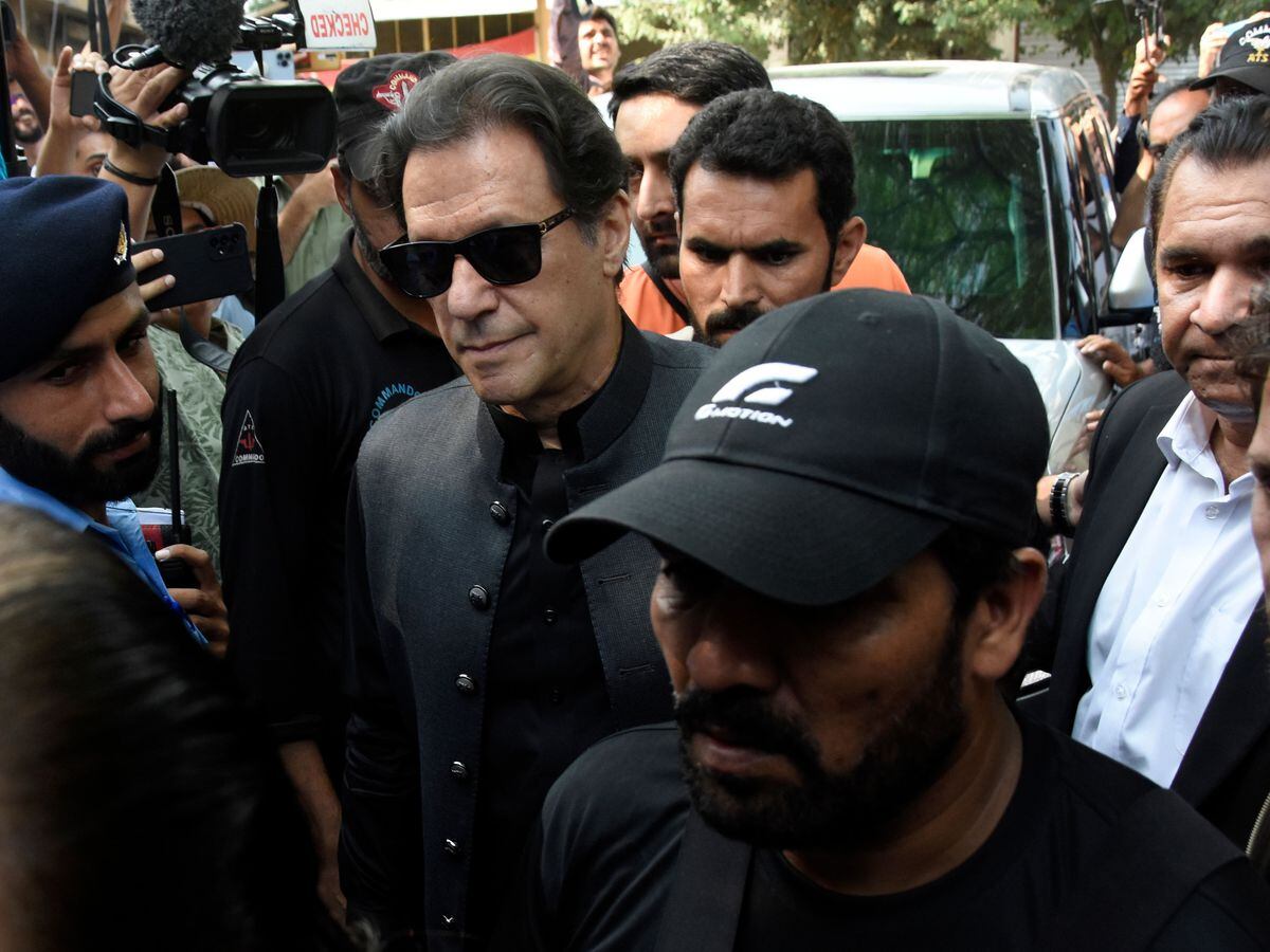 Former Pakistani Prime Minister Imran Khan, centre left, arrives to the Islamabad High Court surrounded by security in Islamabad, Pakistan