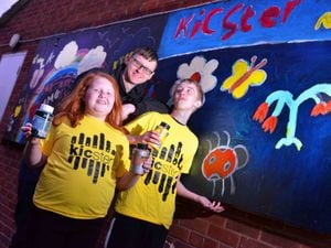 Project manager Ben Williams, Gracie Jones, 10 and Tyler Jones, 13, with an art mural they have worked on