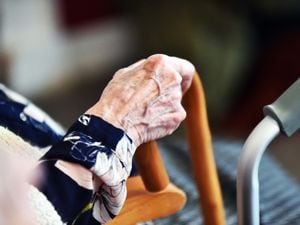 Close up of elderly lady's hand holding her walking stick in a care home