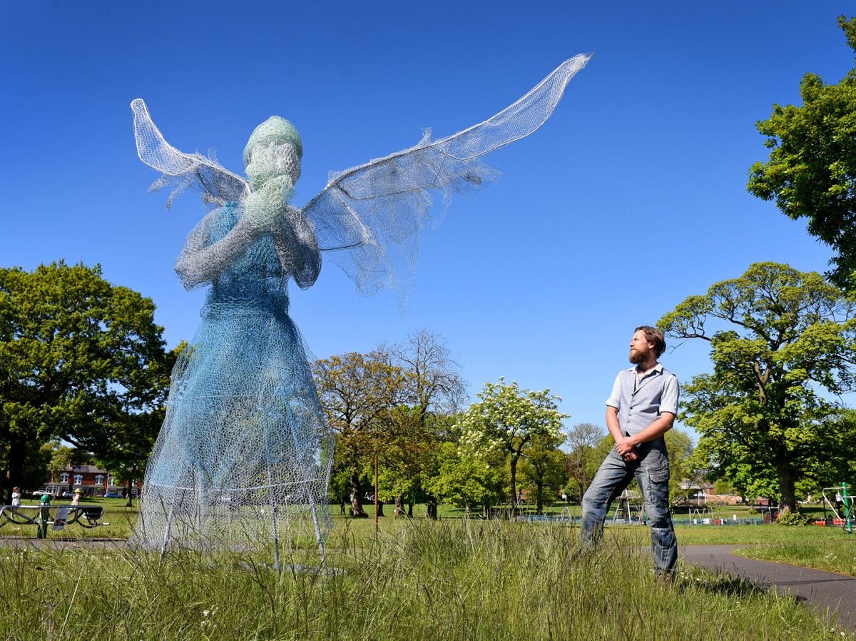 Metal sculptor Luke Perry with his sculpture of a winged medical worker at Lightwoods Park