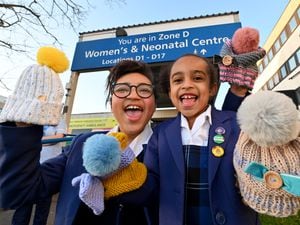 Gabrielle Ellis, aged 10 and sister Sienna, aged six, with some of the hats they knitted for staff at the Neonatal Centre, New Cross Hospital