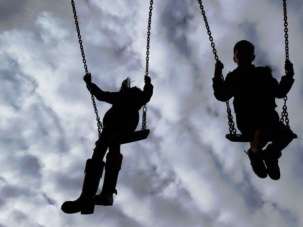 Children enjoy playing on swings in a park (Gareth Fuller/PA)