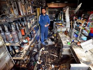 Gursimran Singh Kler from Willenhall surrounded by the damage following a fire at his shop
