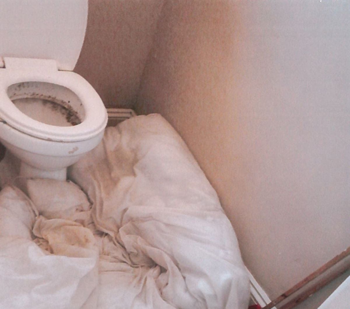 A leaky toilet which had to be plugged by the trafficked tenants, with an old duvet
