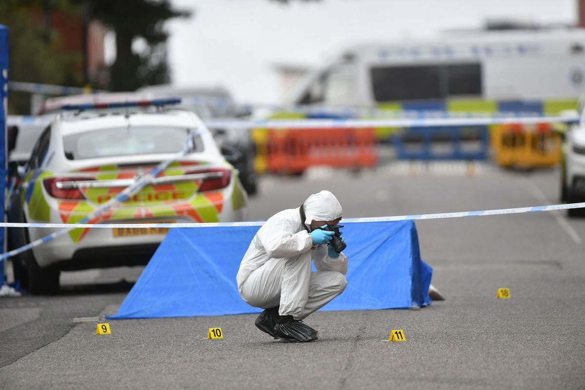 A police forensics officer taking photographs in Irving Street, Birmingham