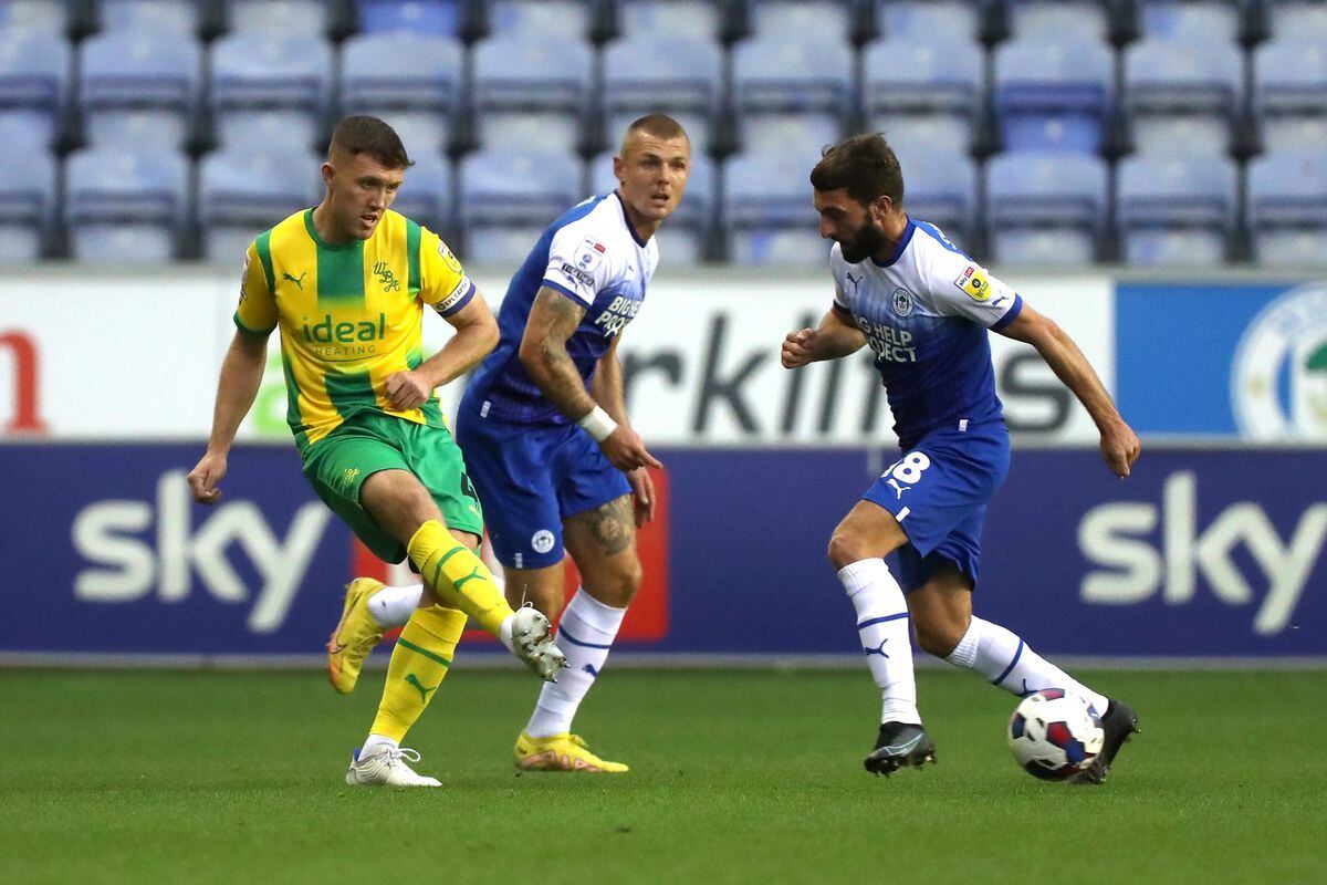 Dara O'Shea of West Bromwich Albion nutmegs Graeme Shinnie of Wigan Athletic during the Sky Bet Championship between Wigan Athletic and West Bromwich Albion at DW Stadium on August 30, 2022 in Wigan, United Kingdom. (Photo by Adam Fradgley/West Bromwich Albion FC via Getty Images).