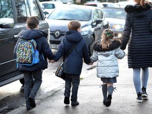 A parent walking their children to school