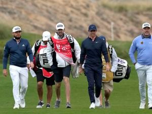 From left to right, England's Tyrrell Hatton, Northern Ireland's Rory McIlroy, Lee Westwood and their caddies, walk on the 12th fairway during the second round of the Abu Dhabi Championship golf tournament at the Yas Links Golf Course, in Abu Dhabi, United Arab Emirates, Friday, Jan. 21, 2022. (AP Photo/Kamran Jebreili).