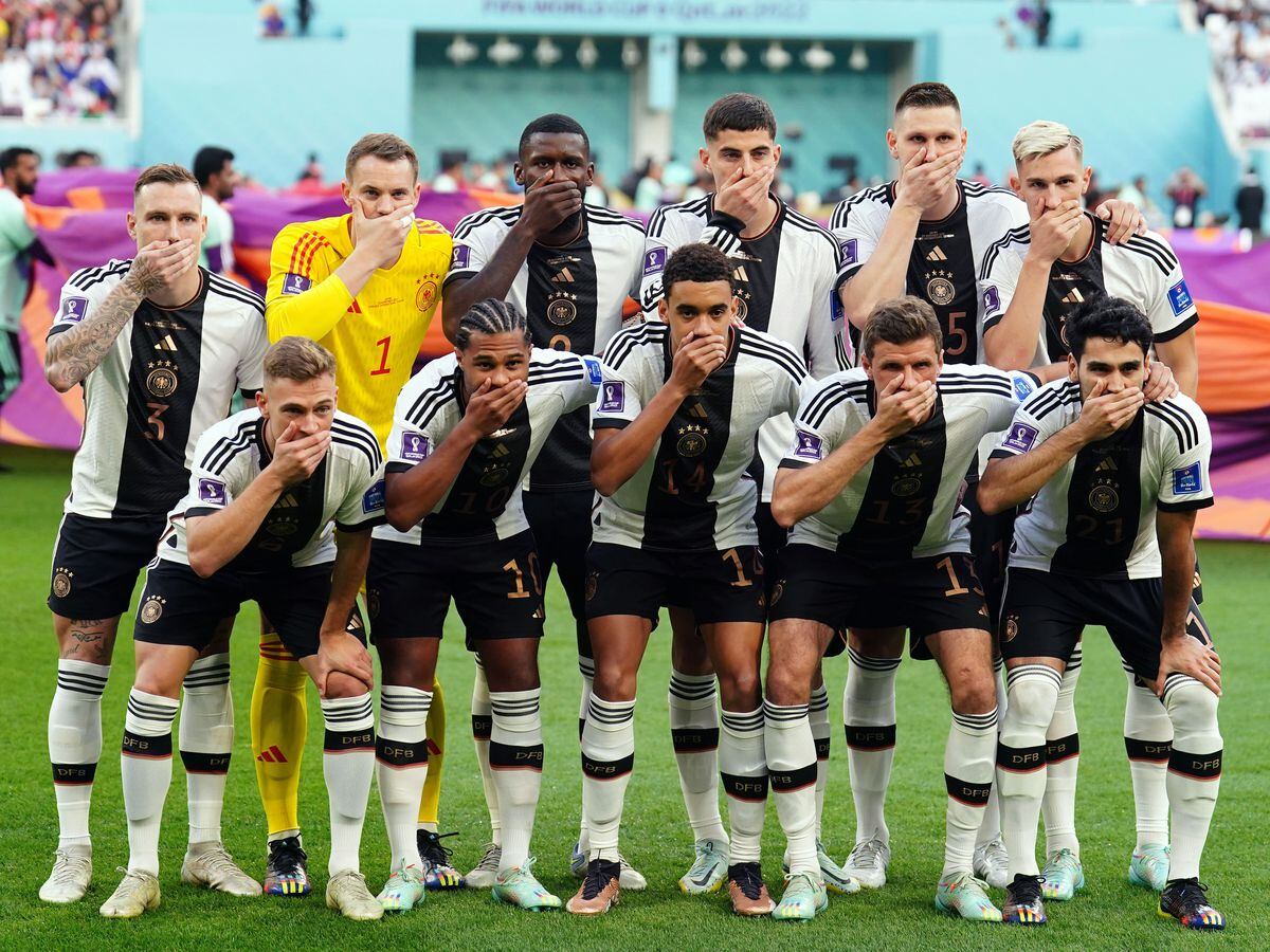 Germany players cover their mouths as they pose for a team photo