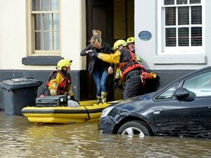 A woman is helped by rescue teams reaching flood victims. Image: Tim Thursfield/Express & Star