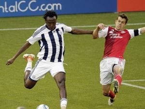 West Bromwich Albion midfielder Gabriel Tamas, left, takes a shot as Portland Timbers defender Eric Brunner defends during the first half of an exhibition soccer game in Portland, Ore., Wednesday, July 20, 2011.(AP Photo/Don Ryan)