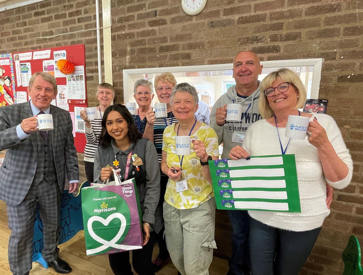 Councillor Chris Towe, Christine Proctor, Morrisons Bescot Community Champion Serina Sahota, Helen Murray, Maureen Thacker, Places of Welcome Coordinator Jane Quinn, Gary Mayo and Debra Mayo raise a cup to the new Place of Welcome