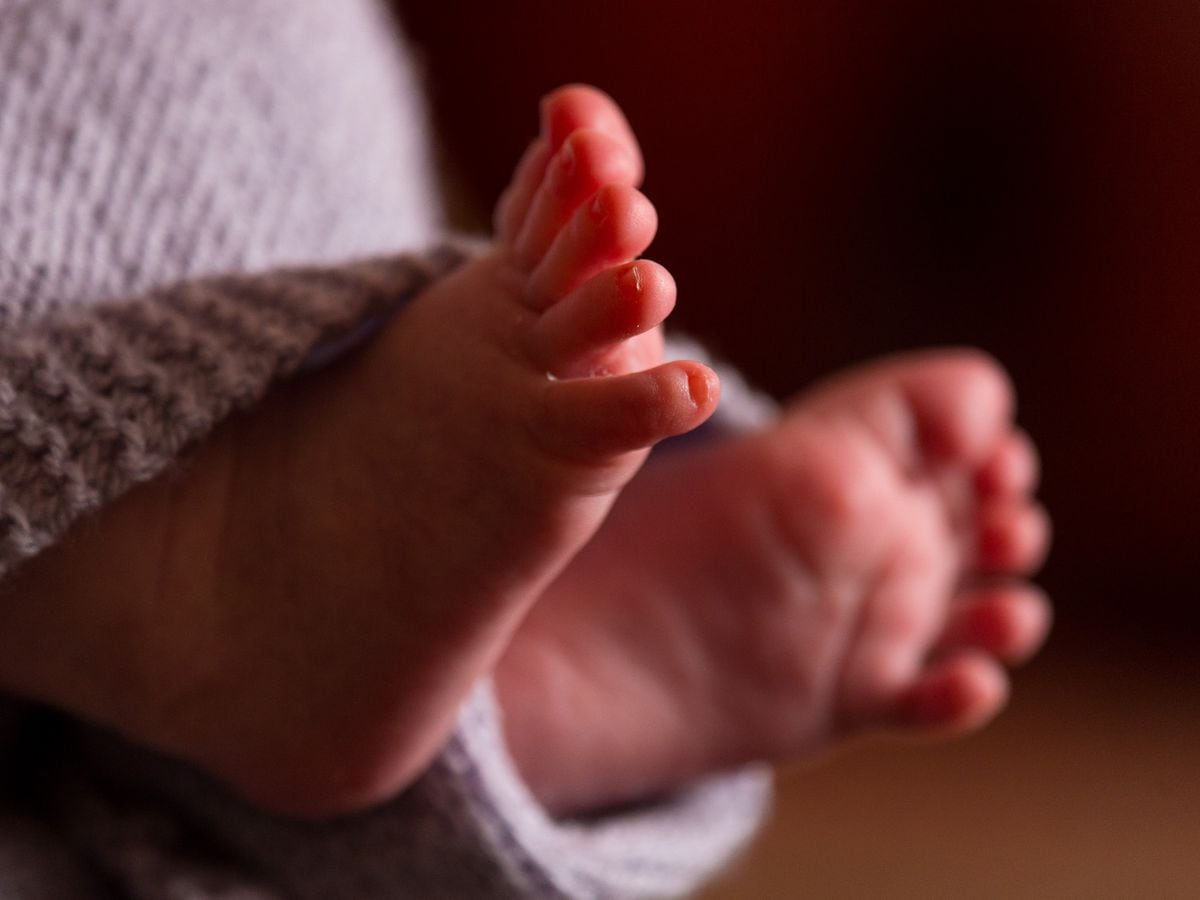 The feet of a new baby wrapped in a blanket