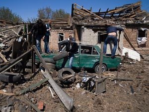 People clean a residential area after a Russian air strike in Bakhmut, Donetsk region, Ukraine