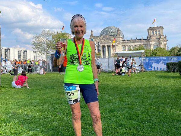 Gina Little celebrates in Berlin after running her 600th marathon