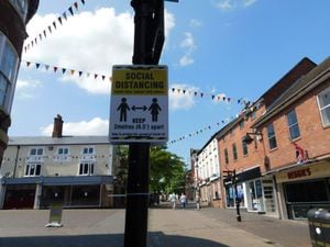 A Sign Reminding Visitors To Practise Social Distancing In Stone High Street With The Lounge In The Background In June 2020