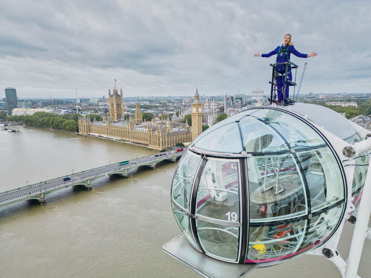 Sally Williams harnessed 135m (443ft) high on top of the London Eye for 20 minutes at 7 am presenting the weather forecast