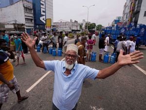A Sri Lankan man shouts in jubilation after a truck carrying cooking gas arrived at a distribution centre in Colombo, Sri Lanka, on Sunday May 8 2022