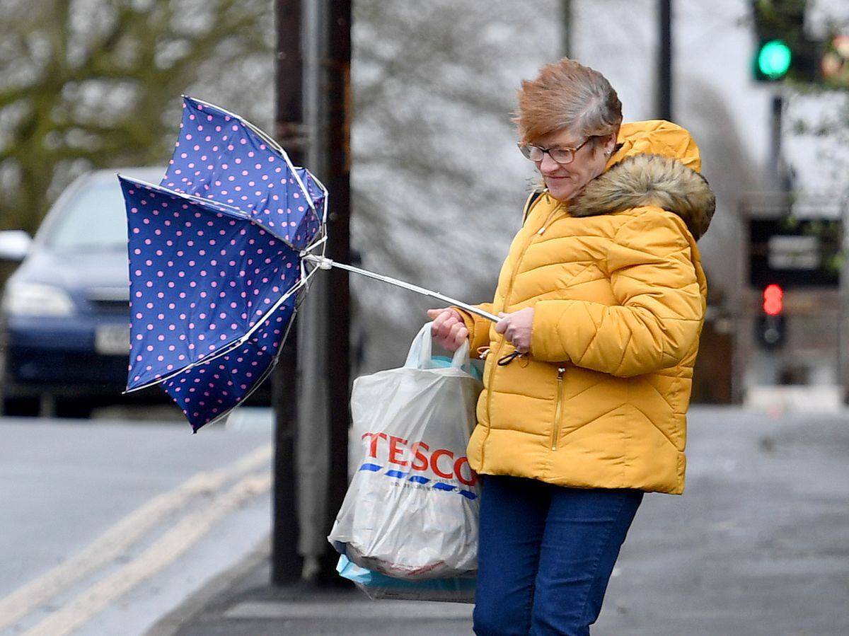A shopper is caught out by the strong wind as she makes her way along Castle Hill, Dudley