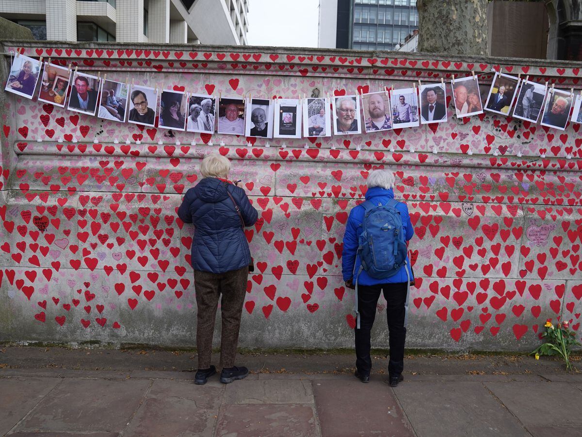 Bereaved families by the Covid memorial wall in central London (Stefan Rousseau/PA)