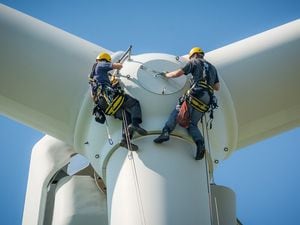 Inspection engineers preparing to rappel down a rotor blade of a wind turbine  