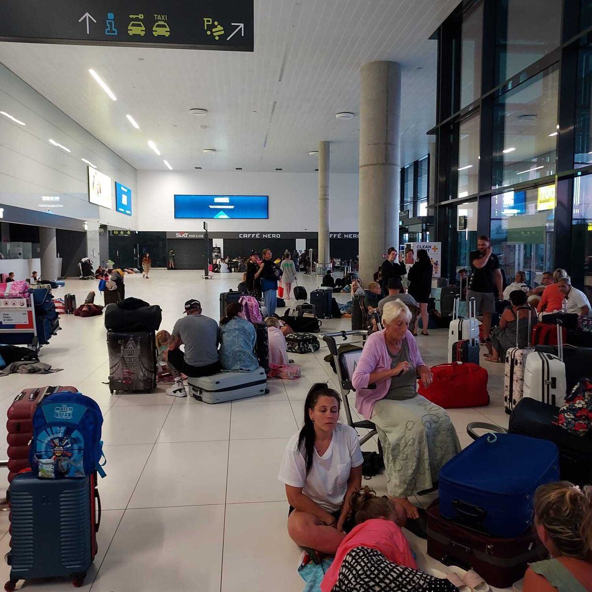 Passengers sitting around Airport floors. Photo: Chris Smith